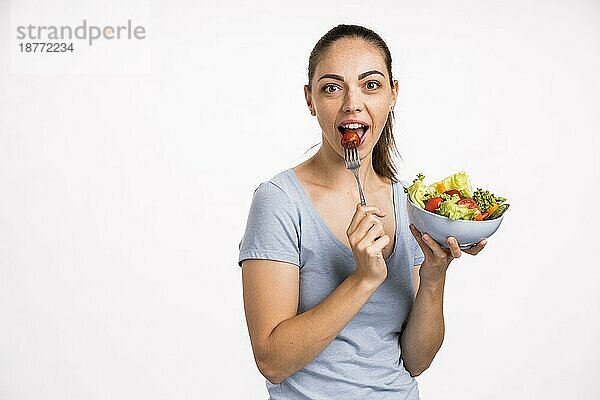 Frau ißt Tomate mit Gabel