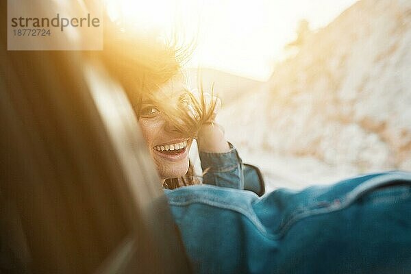 Frau lächelnd während einer Autofahrt