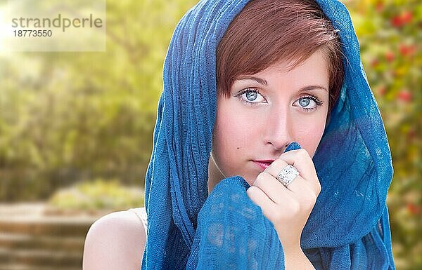 Hübsches blauäugiges junges rothaariges erwachsenes weibliches Porträt im Freien