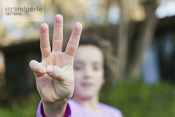 Mädchen zeigt die Geste des Drei-Finger-Grußes