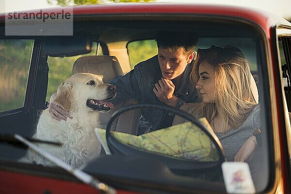 Eine junge Familie  die mit ihrem Hund unterwegs ist