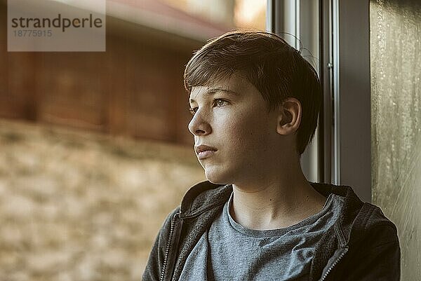 Seitenansicht trauriger Junge schaut nach draußen Foto mit hoher Auflösung