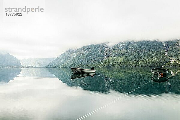 Einsame Boote ruhigen See mit nebligen Berg Hintergrund