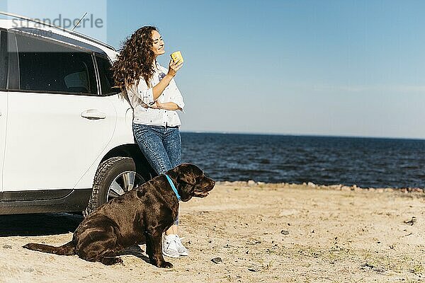 Junge Frau mit ihrem Hund am Strand