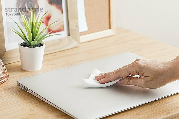 Hoher Winkel Hand desinfiziert Laptop Schreibtisch. Schönes Foto
