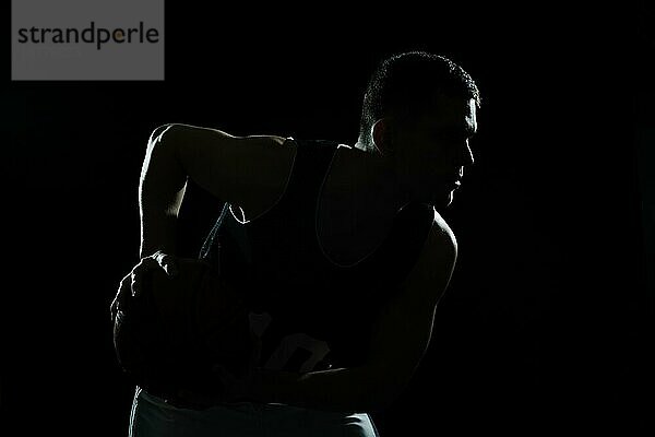 Silhouette Basketballspieler hält Ball schwarzen Hintergrund. Hohe Auflösung Foto