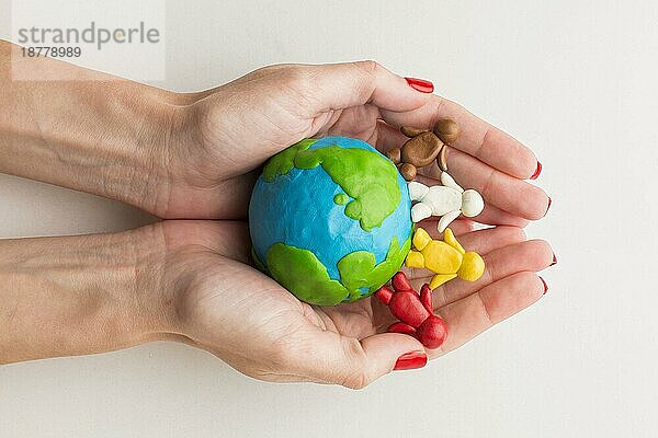 Draufsicht Hände halten Plastilin Globus Menschen. Foto mit hoher Auflösung