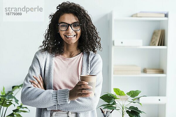 Schöne junge Frau mit Pappbecher Büro