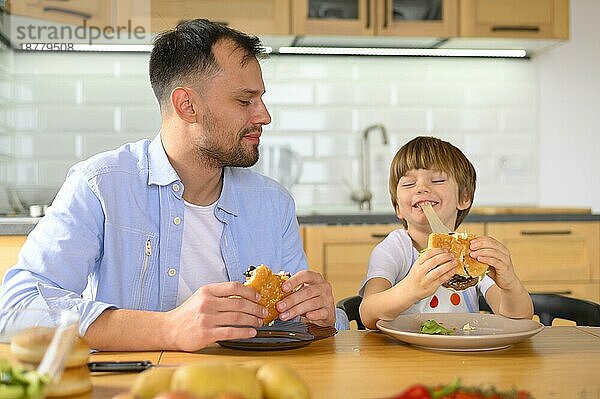 Vater und Sohn essen leckere Burger