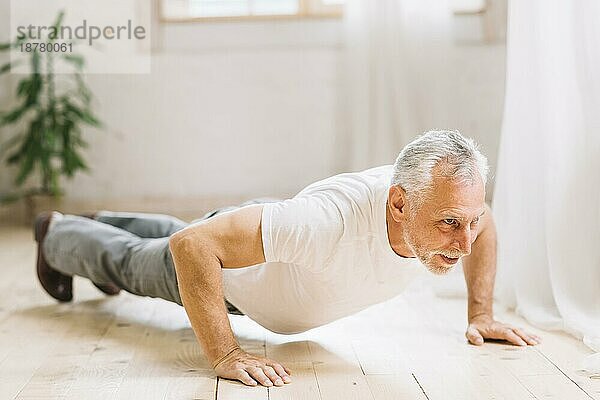 Senior Mann macht Liegestütze Übung Hartholzboden