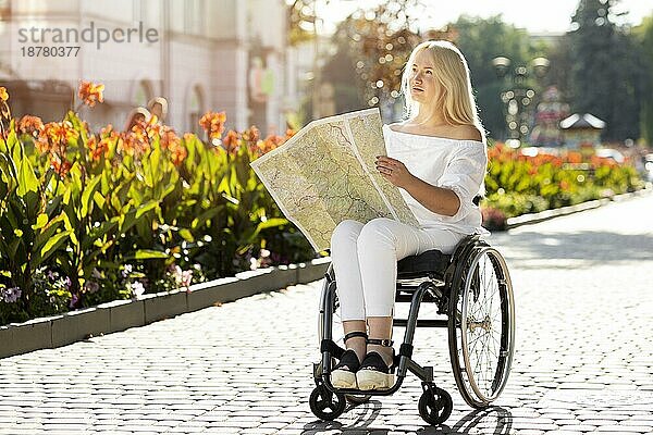 Frau im Rollstuhl sucht Karte im Freien