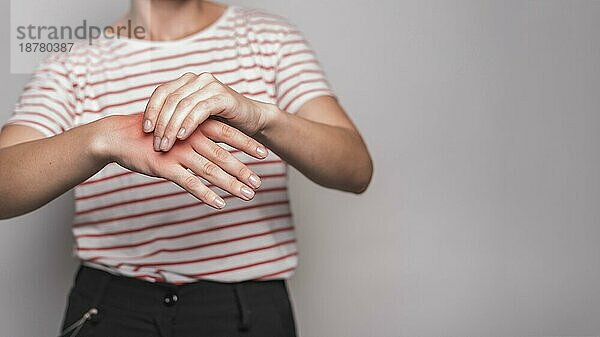 Mitte Abschnitt junge Frau mit Schmerzen Hand gegen grauen Hintergrund. Auflösung und hohe Qualität schönes Foto