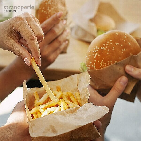Menschen  die Fastfood mit Pommes frites und Hamburgern essen