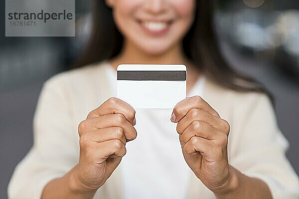 Lächelnde  unscharfe Frau mit Kreditkarte