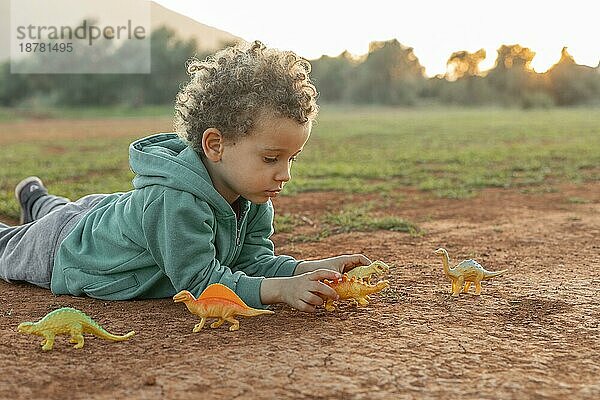 Kleiner Junge spielt im Freien mit Spielzeug