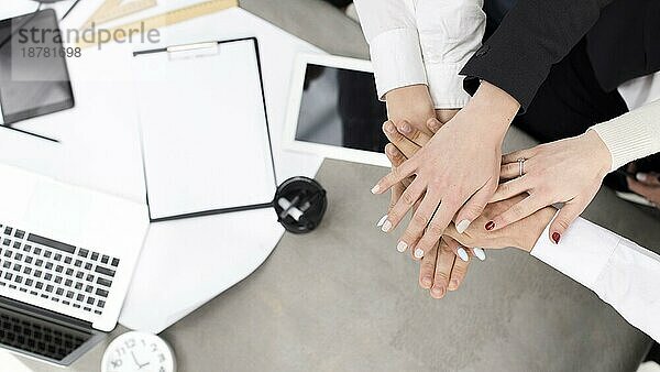Geschäftsleute stapeln sich gegenseitig die Hände auf dem Schreibtisch. Foto mit hoher Auflösung
