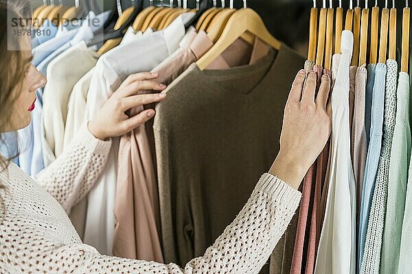 Frau wählt beim Einkaufen Kleidungsstücke aus