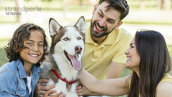 Glücklicher Junge posiert im Park mit Hundeeltern