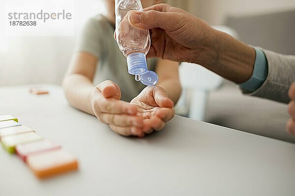 Kind mit Handdesinfektionsmittel vor dem Unterricht nach Hause