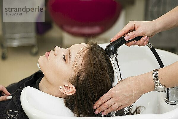 Blondes Mädchen bekommt die Haare gewaschen. Foto mit hoher Auflösung