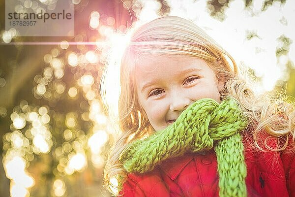 Kleines Mädchen mit Wintermantel und Schal im Park