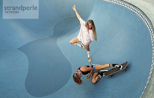 Zwei Freundinnen haben Spaß beim Skateboardfahren. Foto mit hoher Auflösung