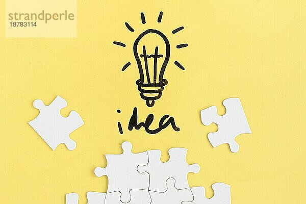Jigsaw Puzzle Glühbirne mit Idee Wort gelben Hintergrund