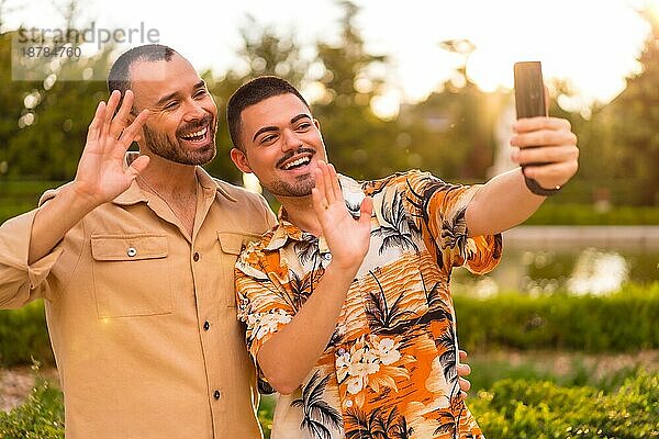 Homosexuelle Freund und Freundin machen ein Selfie oder Videoanruf bei Sonnenuntergang in einem Park in der Stadt. Vielfalt und lgbt Konzept