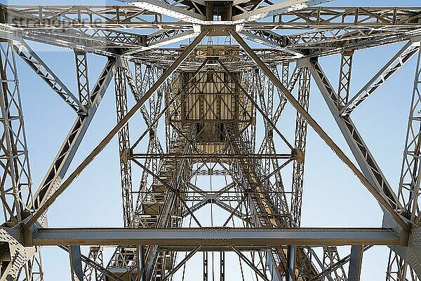 Blick aus der Froschperspektive von unten auf den Torre Sant Sebastia  einen freistehenden Gitterturm mit dreieckigem Querschnitt. Er ist 81 Meter hoch und wird als Endstation der Port Vell Aerial Tramway von Barcelona genutzt