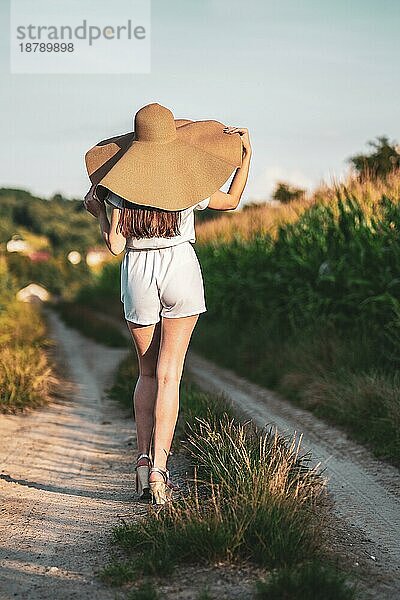 Junge schöne Frau mit Sommerhut im Maisfeld