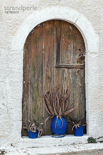 Blumentöpfe vor einer Holztür in dem kleinen Dorf Pitsidia im südlichen Zentrum Kretas. Das Dorf hat seinen ursprünglichen Charakter bewahrt und ist ein beliebtes Ziel im Süden der Insel