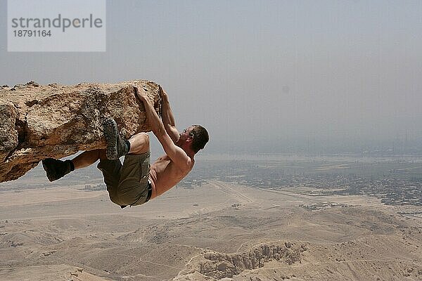 Ein mutiger Kletterer schwebt über dem Tal der Könige in Theben West. Im Hintergrund kann man das grüne Band des Nils erkennen  Ägypten  Afrika