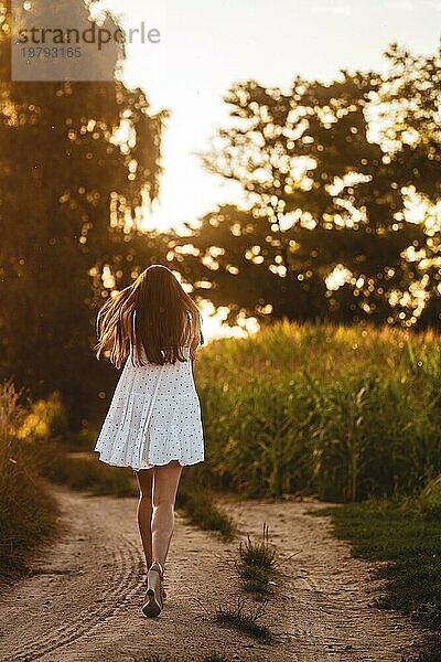 Junge schöne Frau im weißen Kleid im Maisfeld