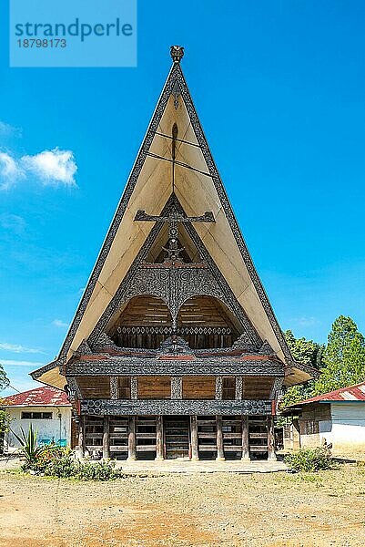 Traditionelle Batak Häuser  auf Indonesisch Rumah Bolon oder Jabu genannt  zeichnen sich durch ihre charakteristischen Dächer aus  die sich an jedem Ende nach oben wölben  wie der Rumpf eines Schiffes  und durch ihr Schnitzdekor