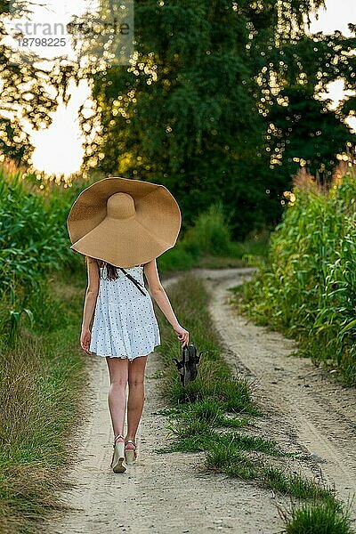 Junge schöne Frau mit Sommerhut im Maisfeld