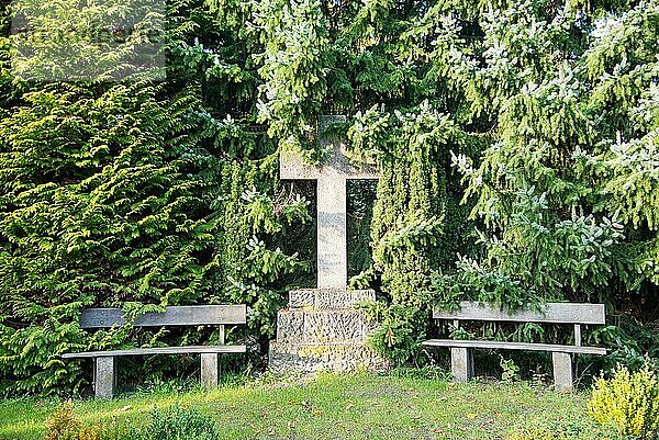 Bank und Heiliges Kreuz auf dem Friedhof im Hamburger Stadtteil Altona. Es ist ein ländlicher  herbstlich gefärbter Friedhof im Norden des Stadtteils. Der Ort lädt zur Ruhe und zur Besinnlichkeit ein