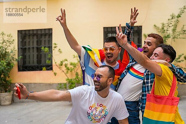 Homosexuelle männliche Freunde  die sich auf einer Gay Pride Party amüsieren und ein Selfie machen  Vielfalt junger Menschen in der Stadt  Straße zur Demonstration mit den Regenbogenfahnen  lgbt Konzept
