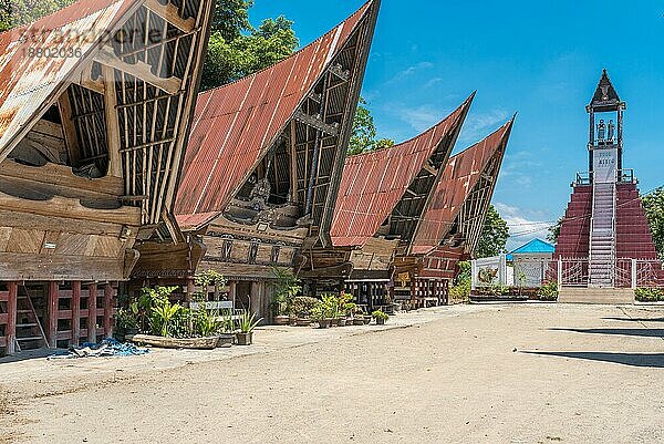 Traditionelles Toba Batak Dorf des Sitio Clans. Die Häuser  die Rumah Bolon oder Jabu genannt werden  zeichnen sich durch ihre charakteristischen Dächer aus  die sich an jedem Ende nach oben wölben  wie der Rumpf eines Schiffes  und durch ihr Schnitzdekor