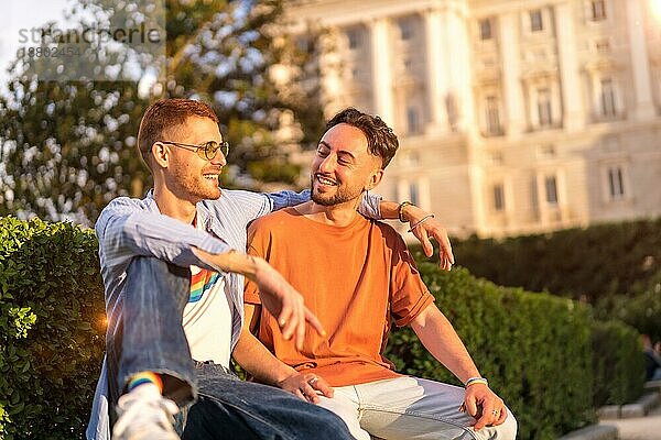 Porträt von Homosexuell Jungvermählten sitzen im Park bei Sonnenuntergang in einem Park in der Stadt. Vielfalt und lgbt Konzept