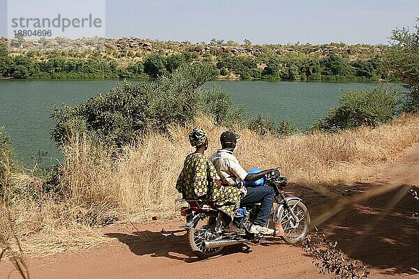 Ein Motorrad mit Besatzung fährt eine Piste entlang dem Senegal-Fluss südlich von Kayes  Mali  Afrika