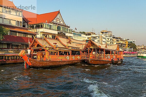 Schiffe an der Anlegestelle für eine Flussfahrt auf einem Reiskahn auf dem Chao Phraya Fluss in Bangkok. Traditioneller Reiskahn  gebaut für die Gastronomie auf dem Fluss