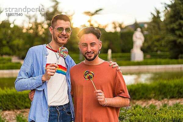 Porträt von Homosexuell Freund und Freundin essen einen Lutscher im Park auf Sonnenuntergang in der Stadt. Vielfalt und lgbt Konzept