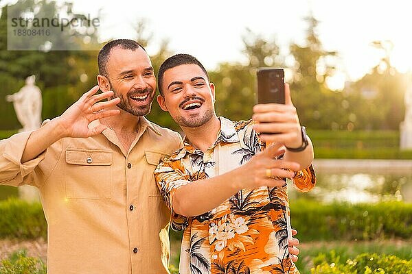 Homosexuelle Freund und Freundin machen ein Selfie oder Videoanruf bei Sonnenuntergang in einem Park in der Stadt. Vielfalt und lgbt Konzept