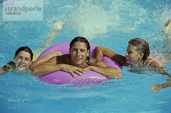 3 junge Frauen im Wasser  1 Frau mit Schwimmring