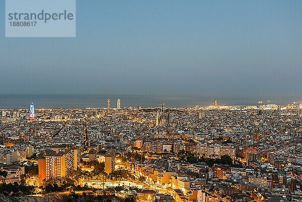 Draufsicht und Nachtaufnahme vom beleuchteten Barcelona. Das Panorama zeigt die berühmte Sagrada Familia  den beleuchteten Torre Agbar und die Türme des Port Olimpic bis zum Hafen