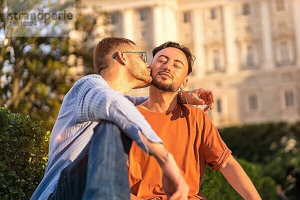 Porträt von Homosexuell Jungvermählten sitzen im Park bei Sonnenuntergang in einem Park in der Stadt. Vielfalt und lgbt Konzept