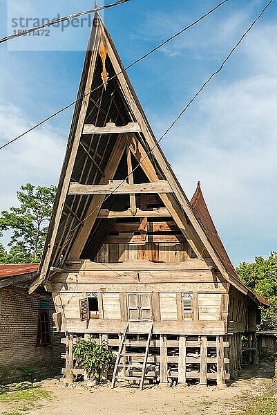 Traditionelle Batak Häuser  auf Indonesisch Rumah Bolon oder Jabu genannt  zeichnen sich durch ihre charakteristischen Dächer aus  die sich an jedem Ende nach oben wölben  wie der Rumpf eines Schiffes