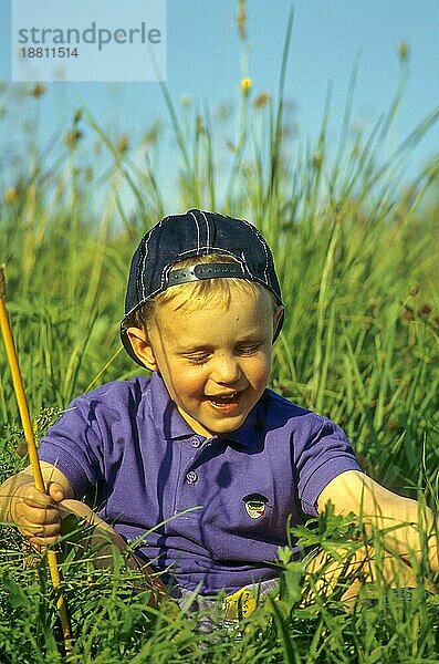 Kind unter 2 Jahre  kleiner Junge im Gras sitzend