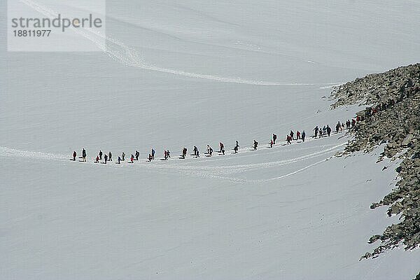 Bergwanderer betreten aus Sicherheitsgründen den Gletscher am Goldhopigen in Zweierreihen  Norwegen  Europa