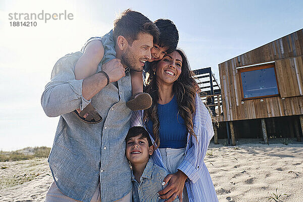 Glückliche Familie  die gemeinsam Spaß vor dem Strandhaus hat